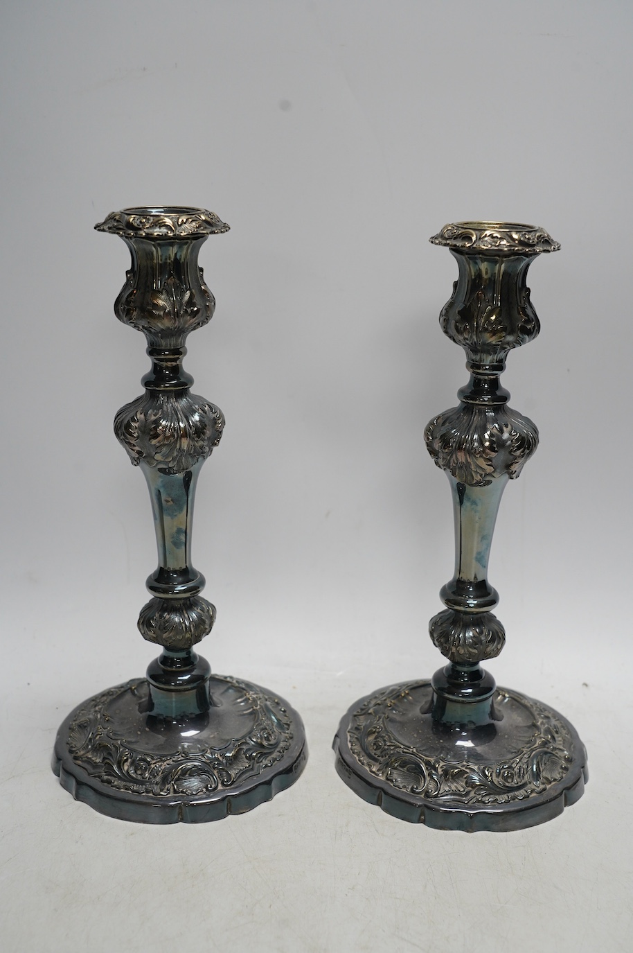 A pair of silver plated candlesticks, a pair and another wine coaster, and a cocktail shaker, tallest 25cm. Condition - fair